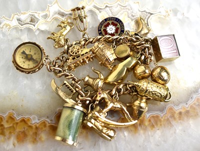 Lot 145 - A 9ct gold charm bracelet with 19 charms,...
