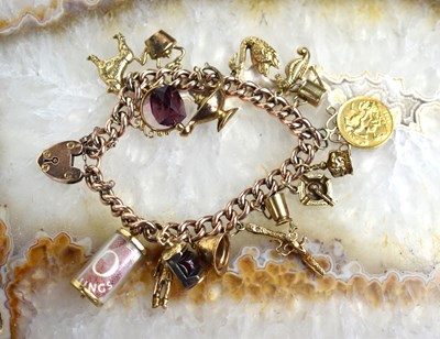Lot 153 - A 9ct gold charm bracelet with fifteen charms...