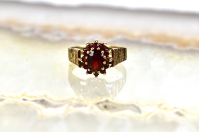 Lot 55 - A 9ct gold and garnet cluster ring, size M, 2.6g.