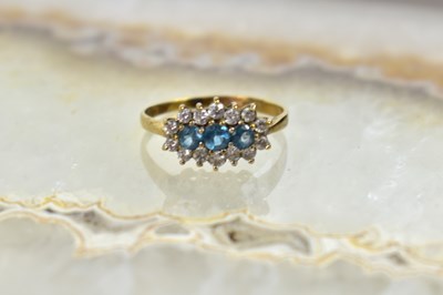Lot 54 - A 9ct gold, three stone blue topaz and diamond...