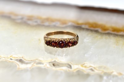 Lot 110 - A 9ct gold and garnet five stone ring, size...