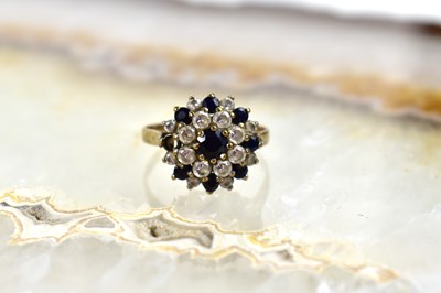 Lot 111 - A 9ct gold, diamond and sapphire cluster ring,...