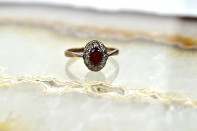 Lot 97 - A 9ct gold, diamond and garnet flowerhead ring,...