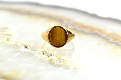 Lot 108 - A 9ct gold and tigers eye ring, size Z 1/2, 6.2g.