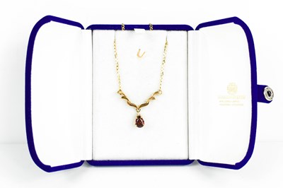 Lot 239 - A 9ct gold, garnet and white sapphire pendant...