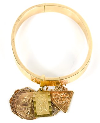 Lot 16 - An 18ct gold bangle with five 9ct gold St...