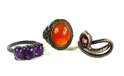 Lot 185 - Three rings: a white metal, enamel and agate...
