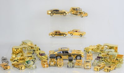 Lot 100 - A group of gold coloured model cars, some by...