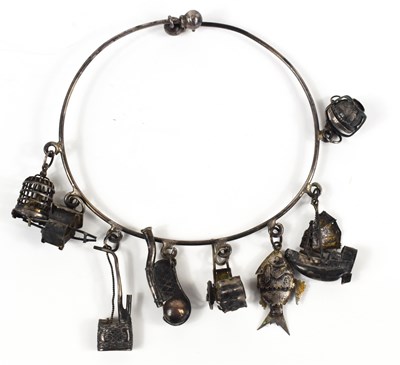 Lot 320 - A Chinese white metal charm bangle, suspended...