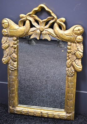 Lot 311 - A modern giltwood wall mirror, with bow form...