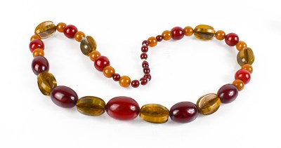 Lot 431 - A necklace composed of red amber, cloudy amber...