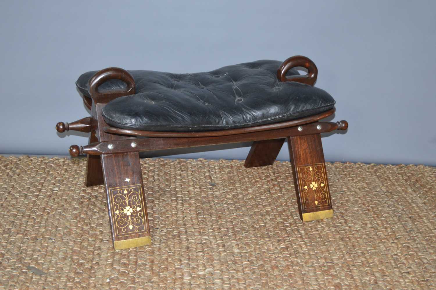 Lot 272 - A brass inlaid and leather camel saddle stool.