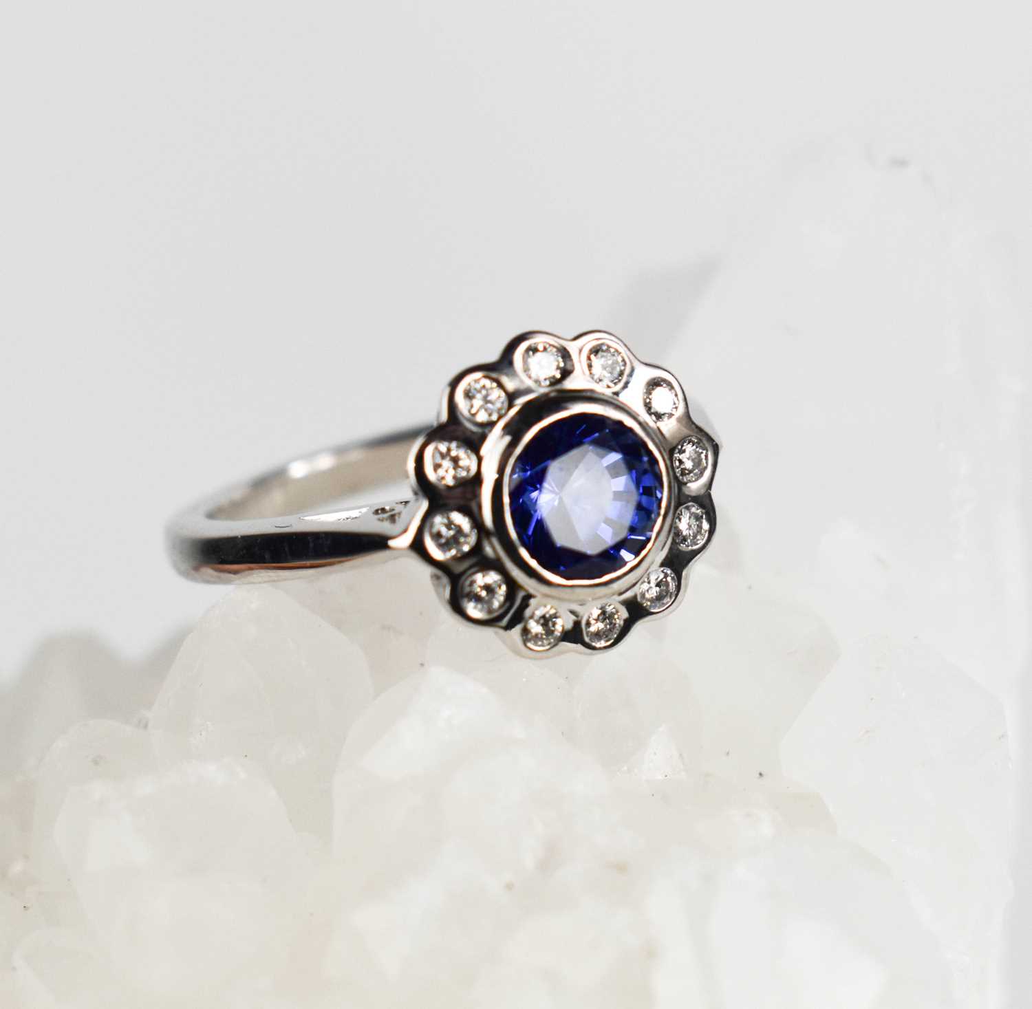 Lot 446 - An 18ct white gold sapphire and diamond...