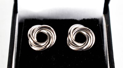 Lot 420 - A pair of platinum earrings, in a knot design,...