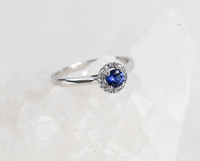 Lot 419 - A 9ct white gold, sapphire and diamond halo...