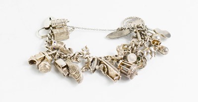 Lot 319 - A silver charm bracelet with twenty four...