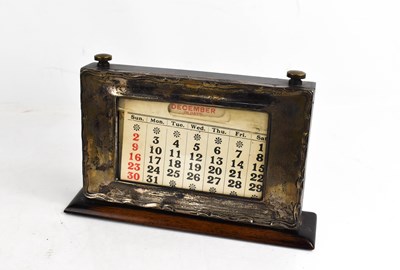 Lot 314 - A silver fronted desk calendar, with ebonised...