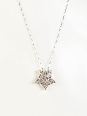 Lot 438 - A 14ct white gold star form opening pendant...