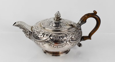 Lot 63 - A Georgian silver teapot, embossed with...