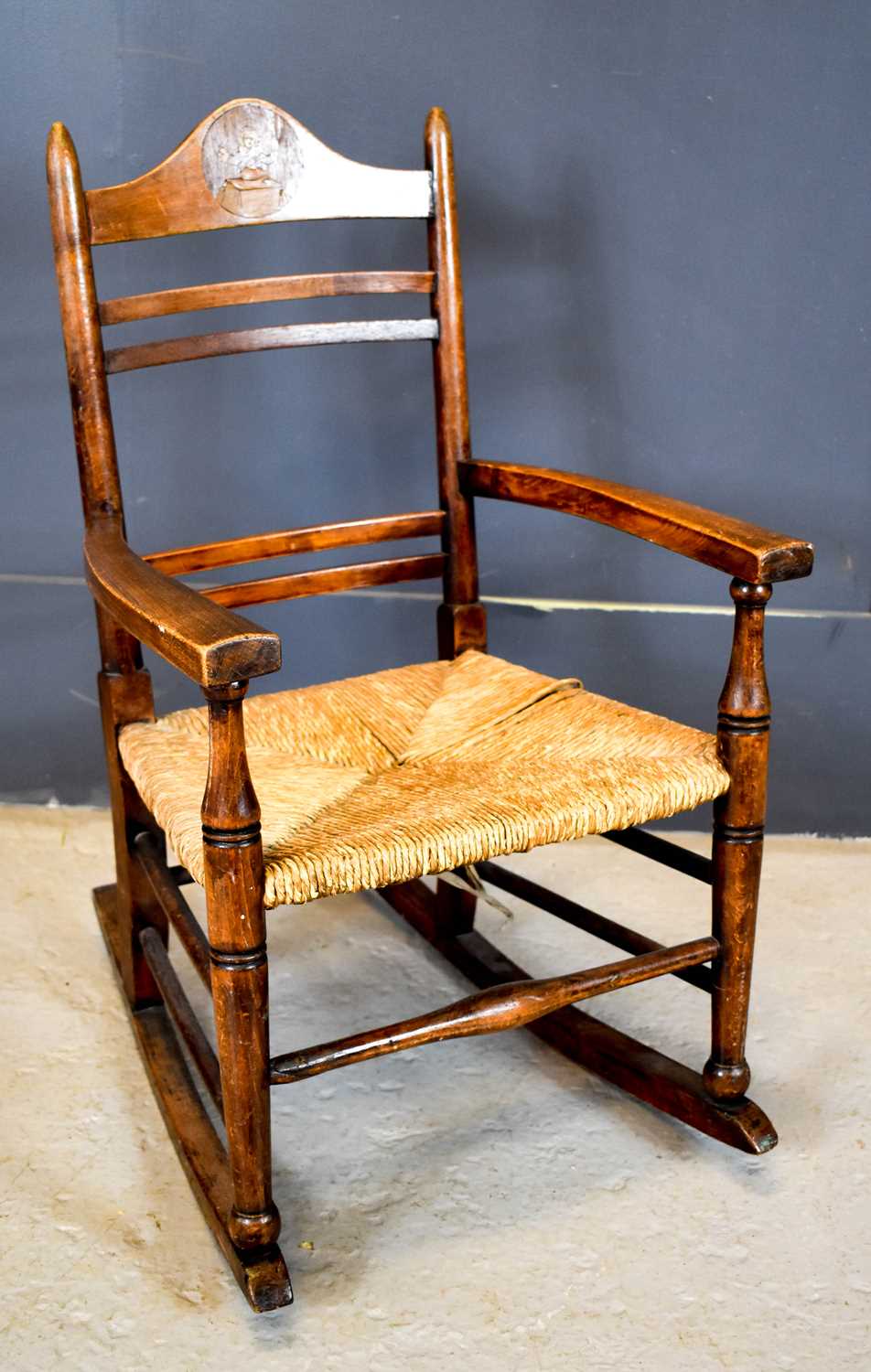 Lot 559 - An Arts and Crafts child's rocking chair, with...