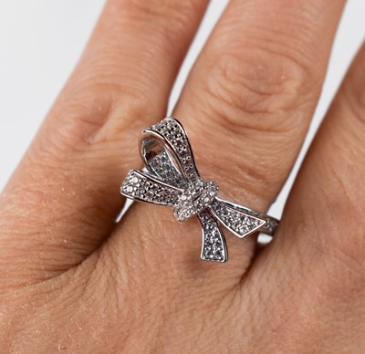 Lot 21 - A silver bow knot pave ring, set with...