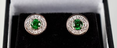 Lot 154 - A platinum, diamond and tsavorite pair of halo...