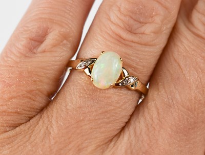 Lot 61 - A 9ct gold oval opal and diamond ring, the...