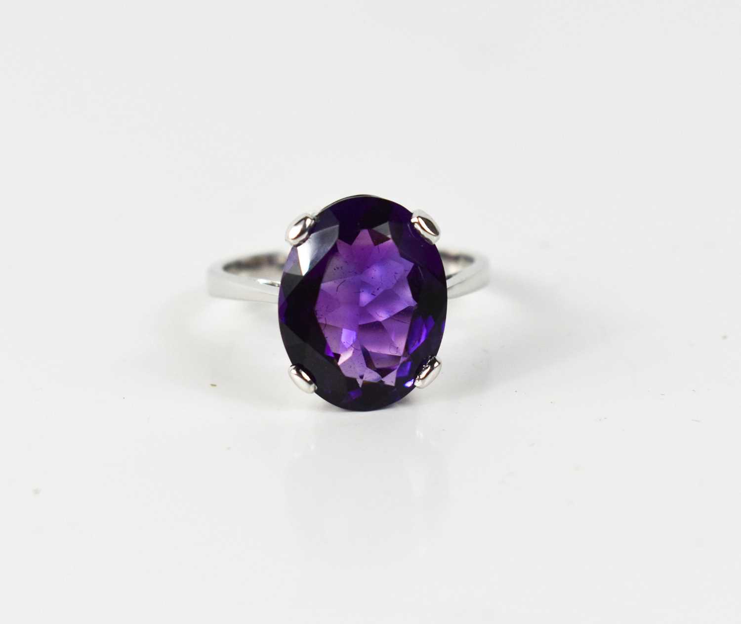 Lot 62 - A 9ct white gold and oval amethyst ring, the...