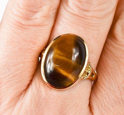 Lot 43 - A 9ct gold and tigers eye oval cabochon ring,...