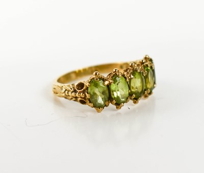 Lot 23 - A 9ct gold and peridot five stone ring, each...