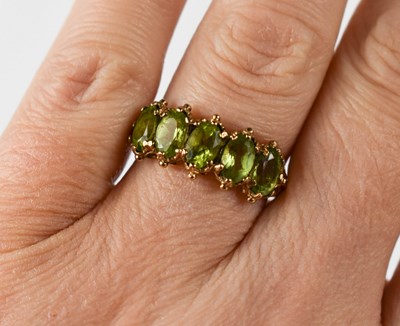 Lot 23 - A 9ct gold and peridot five stone ring, each...