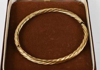 Lot 126 - A 9ct gold twist bangle, hinged with clasp...
