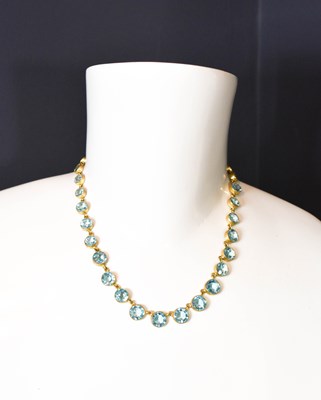 Lot 173 - An aquamarine blue paste riviere necklace, of...