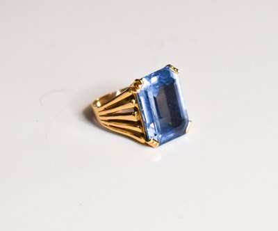 Lot 10 - A gold dress ring set with emerald cut blue...