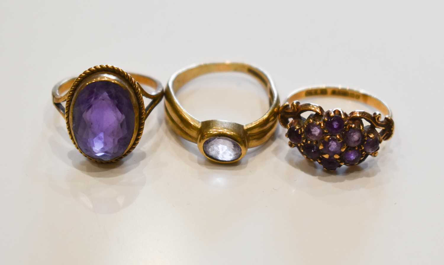 Lot 26 - A group of three 9ct gold and amethyst dress...