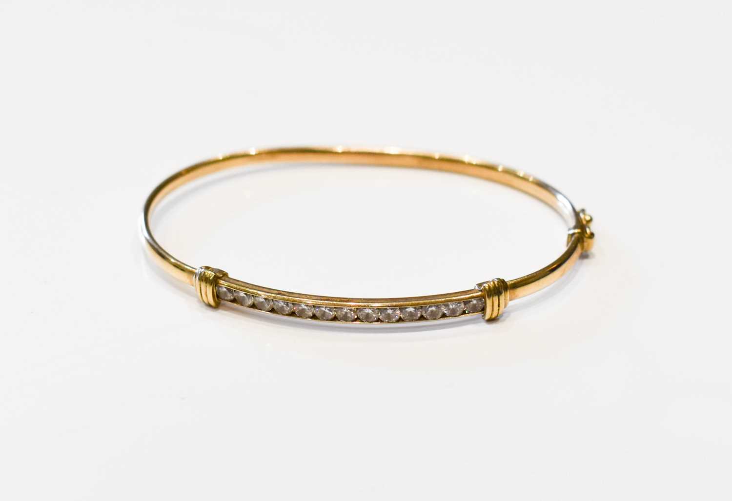 Lot 193 - A 9ct gold bangle set with thirteen white...