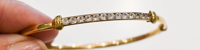 Lot 193 - A 9ct gold bangle set with thirteen white...