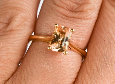 Lot 165 - An 18ct gold and peach sapphire dress ring,...