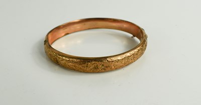 Lot 119 - A 9ct gold bangle with foliate engraving, 60...