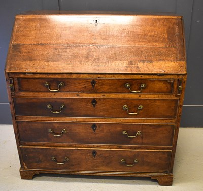 Lot 659 - A George III oak provincial bureau, fitted...