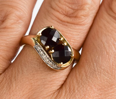 Lot 130 - A 9ct gold two stone garnet and diamond ring,...