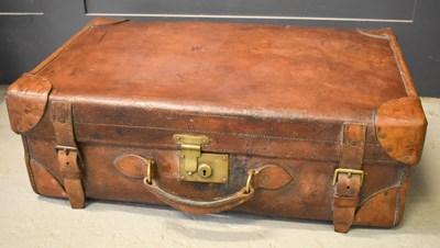 Lot 180 - A large antique leather suitcase bearing...