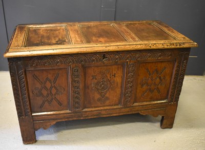 Lot 418 - A 17th century oak coffer with three panel lid,...