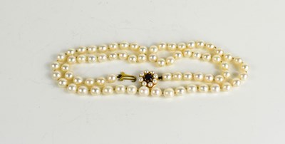 Lot 100 - A string of pearls with 9ct gold and garnet...
