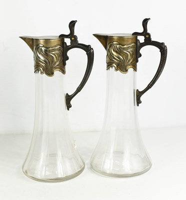 Lot 15 - A pair of Art Nouveau silver plated claret jugs.
