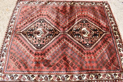 Lot 615 - A Persian wool rug with red / brown ground,...