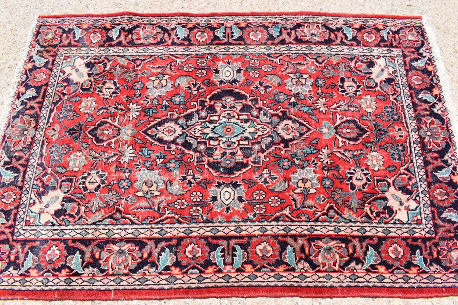 Lot 430 A Persian wool rug with red ground, the
