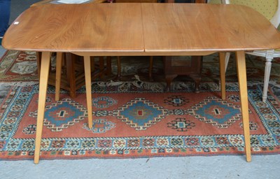 Lot 655 - A mid-century Ercol elm extending dining table.