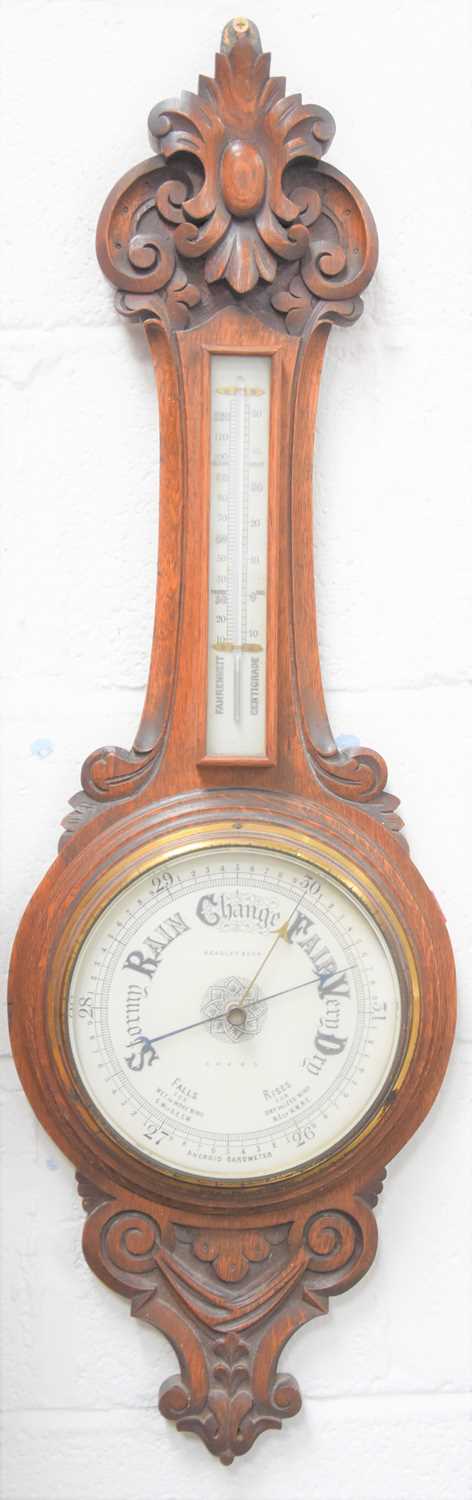 Lot 14 - A Victorian carved oak cased aneroid barometer,...