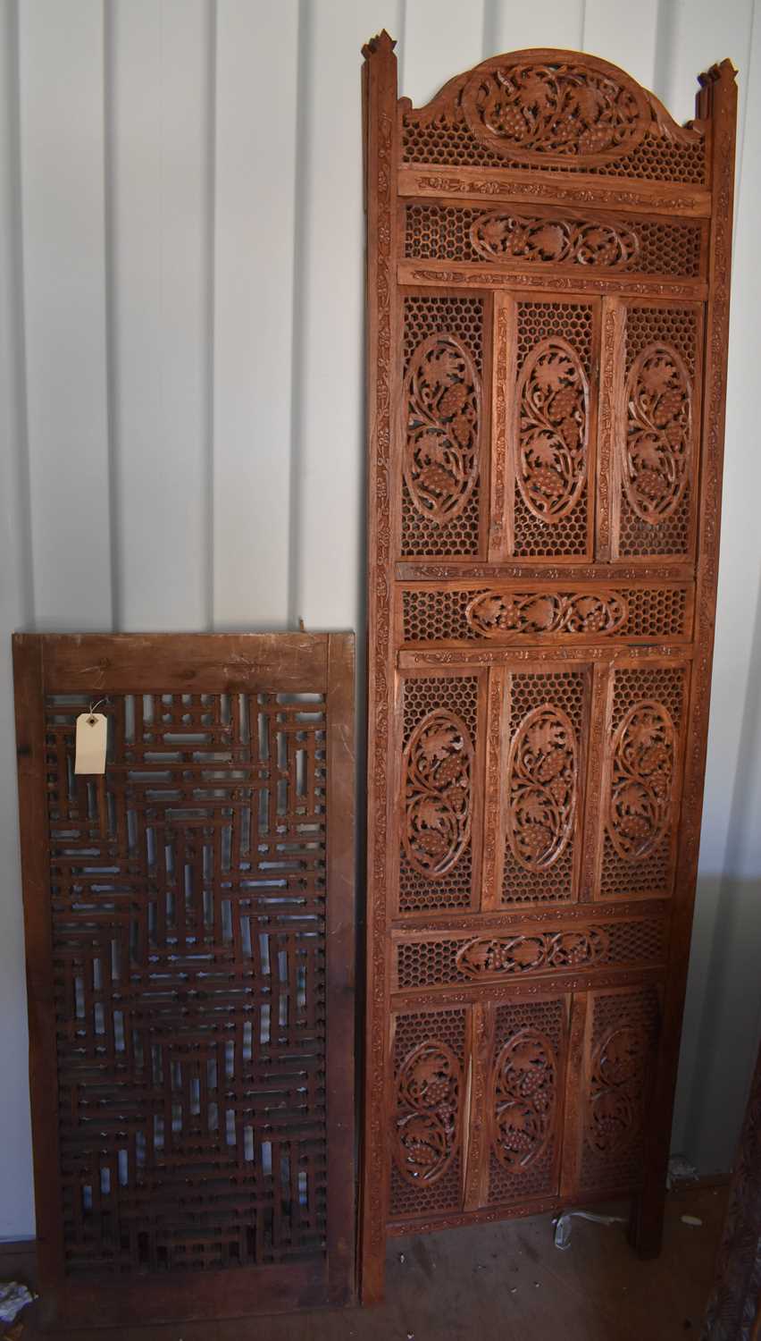 Lot 489 - A bi-fold Indonesian hardwood carved screen,...